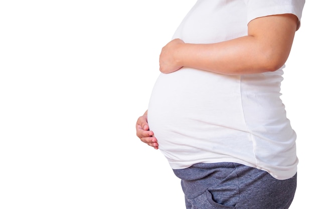 Femme enceinte touchant son ventre isolé sur mur blanc