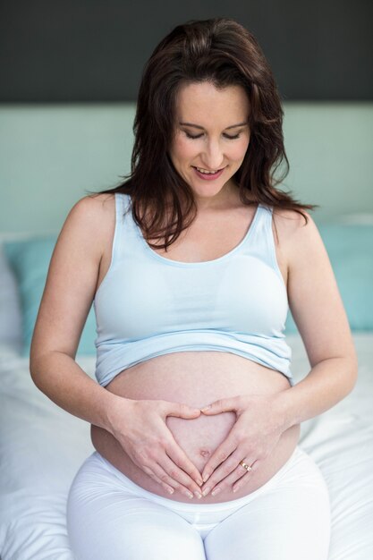 Femme enceinte toucher son ventre dans sa chambre