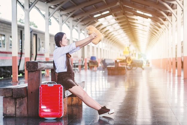 Photo femme enceinte, voyageur, séance, sur, étreindre, nounours, à, a, rouges, valise, à, ferroviaire, stati