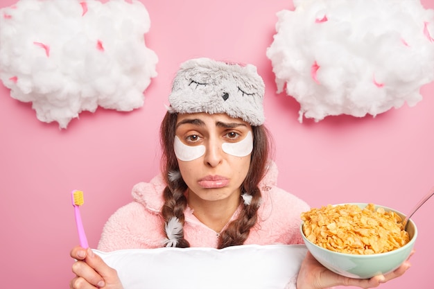 Une femme endormie bouleversée et fatiguée des routines du matin regarde tristement la caméra