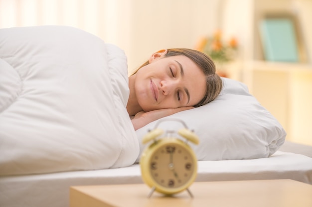 La femme endormie sur le fond d'une horloge