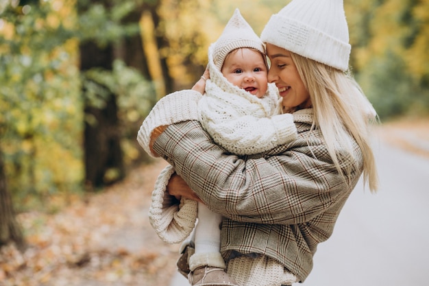 Femme avec enfant en bas âge dans le parc d'automne