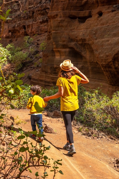 Photo une femme et un enfant marchent sur un sentier de terre.