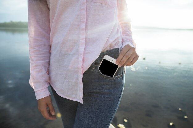 Photo femme enlevant le téléphone portable de la poche