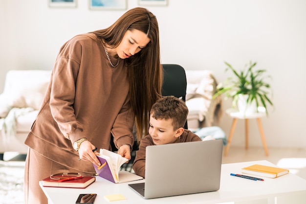 Femme enseignant un garçon à la maison