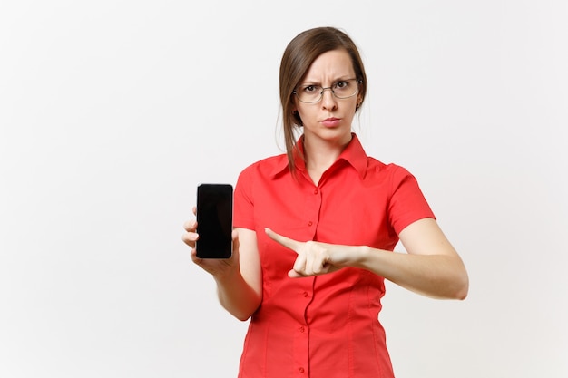 Une femme enseignante sérieuse et stricte en chemise rouge tient un téléphone portable avec un écran vide vierge, montrant un geste d'arrêt avec une paume isolée sur fond blanc. Enseignement de l'éducation dans le concept d'université de lycée.