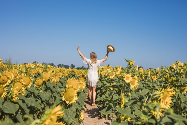 Femme ensoleillée de beauté sur le champ de tournesol jaune Concept de liberté et de bonheur Fille heureuse à l'extérieur