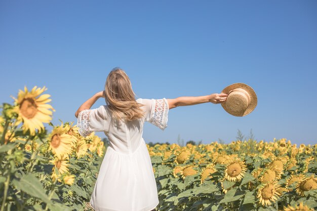 Femme ensoleillée de beauté sur le champ de tournesol jaune Concept de liberté et de bonheur Fille heureuse à l'extérieur