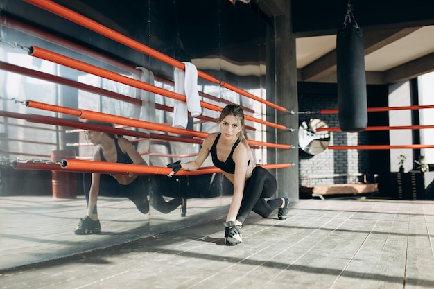 Femme entraînement matinal dans la salle de sport. Jeune femme faisant de l'exercice dans la salle de sport