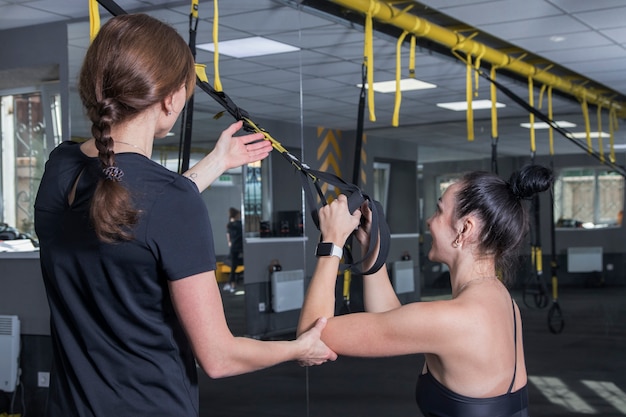 Femme avec entraîneur fait du sport dans la salle de sport