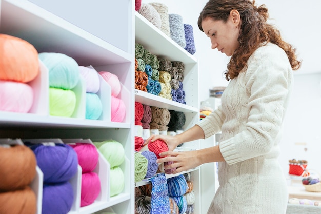 Femme entreprenante dans sa propre boutique de vente au détail de fils de laine