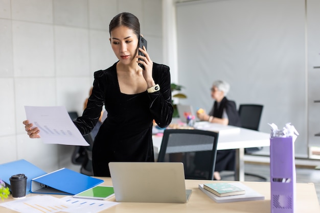 Femme d'entrepreneur asiatique souriante occupée à travailler sur un téléphone portable au bureau à domicile. Espace de copie de fond de bannière