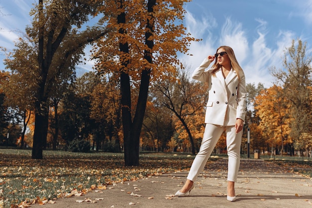 Femme entrepreneur bien habillée et confiante en costume blanc et lunettes de soleil