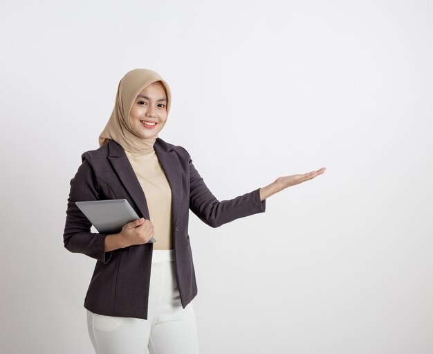 Femme entrepreneur portant le hijab souriant avec tenant la tablette montrant l'espace de copie, concept de travail formel