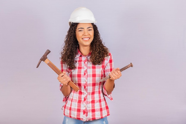 Femme entrepreneur tenant un marteau et un couperet.