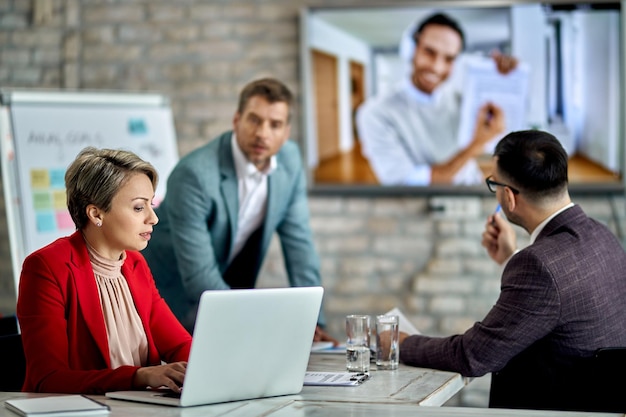 Femme entrepreneur utilisant un ordinateur portable lors d'une réunion de vidéoconférence d'affaires au bureau