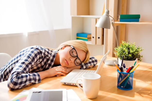 Femme épuisée de dormir au bureau après une dure journée de travail