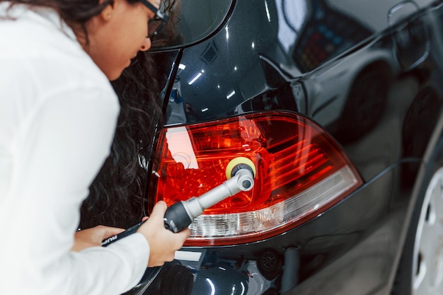 Femme avec équipement de nettoyage automobile moderne Conception de service