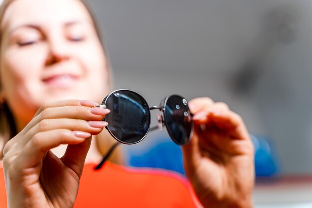 Femme essayant des lunettes dans un magasin d'optique