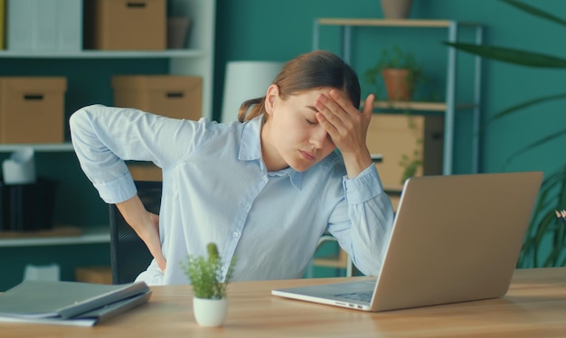 Femme essayant de se lever de la table ressentant soudainement une douleur dans le dos