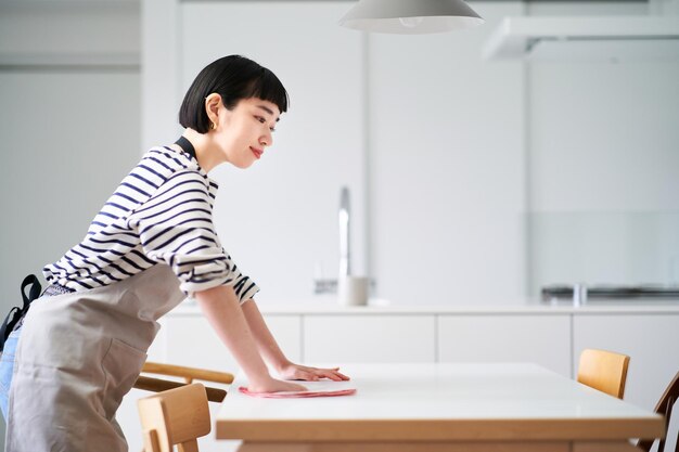 Femme essuyant la table à manger