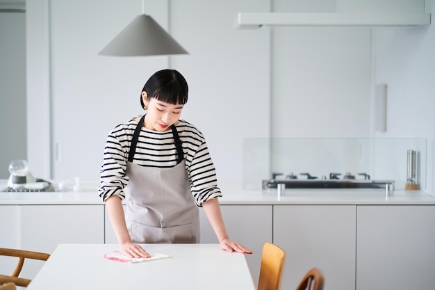 Femme essuyant la table à manger