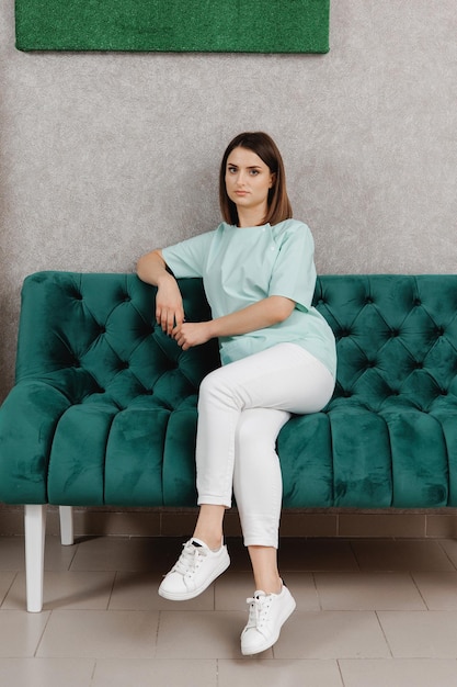 Photo une femme est assise sur un canapé avec une chemise verte