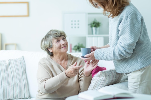 Une femme est assise sur un canapé et parle à une femme.