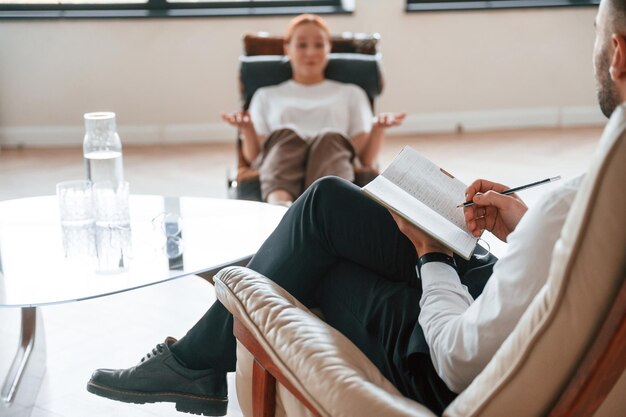 Photo une femme est assise sur une chaise lors d'un rendez-vous avec un psychologue.