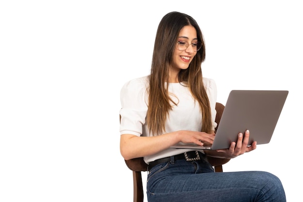 Une femme est assise sur une chaise et utilise un ordinateur portable Espace de copie de fond blanc isolé