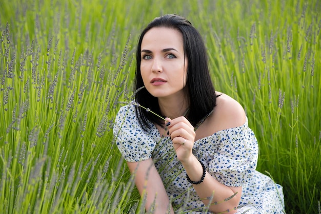 Une femme est assise dans un champ de fleurs.