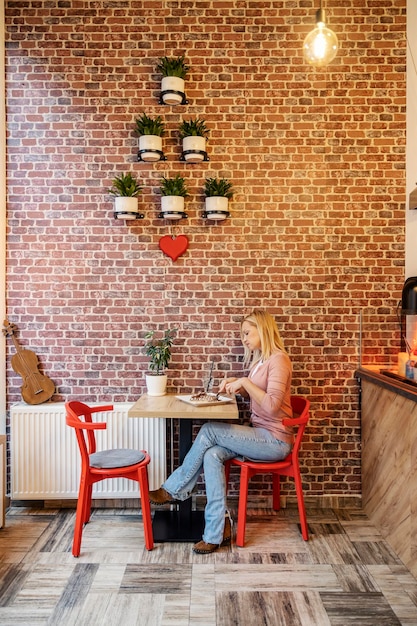 Une femme est assise dans une crêperie et mange des crêpes