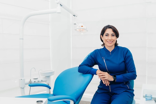 Une femme est assise dans un fauteuil dentaire dans un cabinet dentaire.