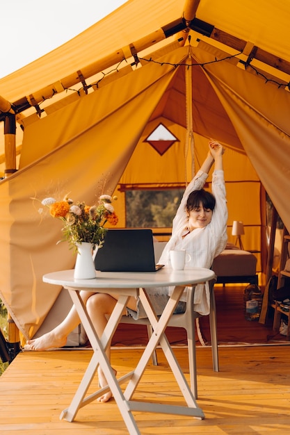 Photo une femme est assise dans une tente avec un ordinateur portable sur ses genoux