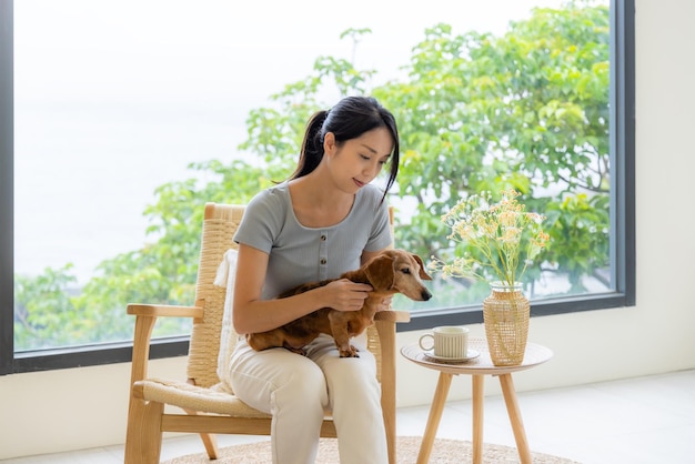 Une femme est assise à l'intérieur d'un café avec son chien.