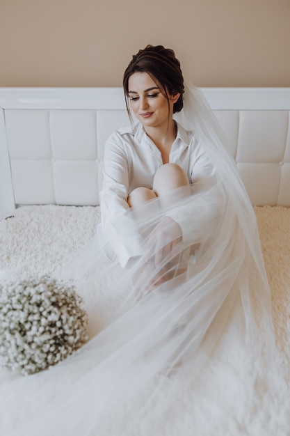 Une femme est assise sur un lit avec un bouquet de fleurs sur ses genoux