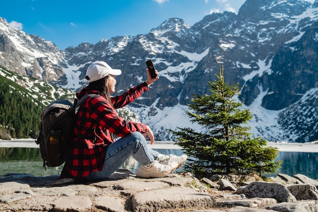 Une femme est assise sur la rive d'un lac Morskie Oko Tatras