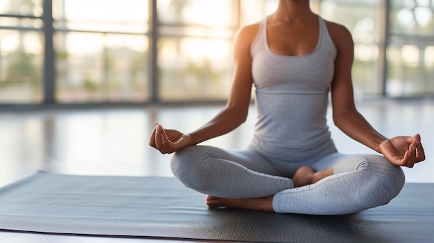 Une femme est assise sur un tapis et pratique le yoga, un concept de calme et de relaxation.