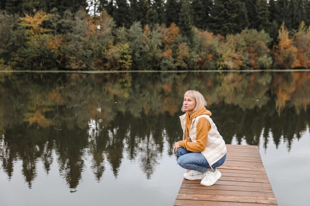 La femme est dans le parc d'automne Atmosphère d'automne vue panoramique sur la rivière