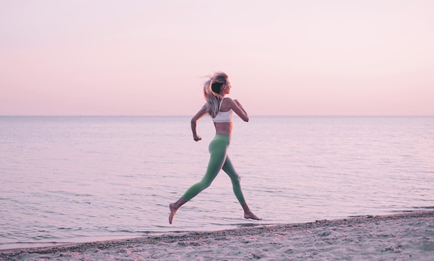 La femme est engagée dans des exercices sportifs sur la plage