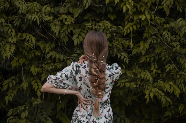 Photo femme esthétique dans la forêt aux longs cheveux blancs avec une robe à fleurs