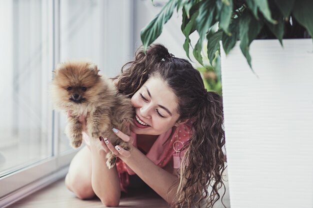 Femme, étreindre, petit chien, dans pièce