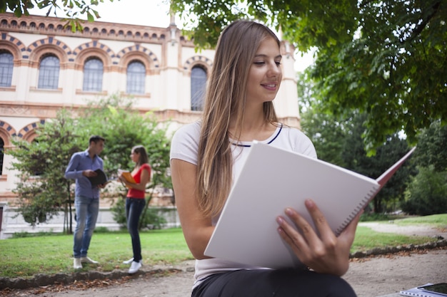 Femme étudiant assis à l&#39;extérieur