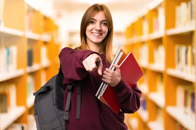 Femme étudiante pointant vers l&#39;avant sur fond flou. retour à l&#39;école