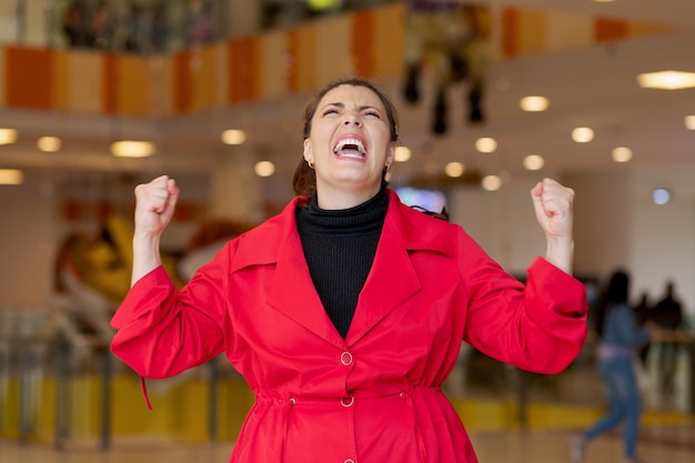 Photo une femme euphorique pose avec les poings levés dans un bonheur imparable