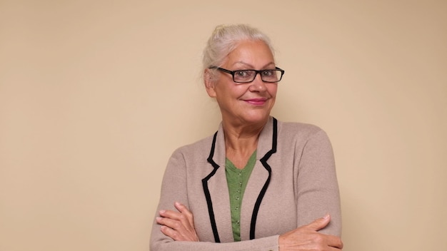 Une femme européenne âgée à lunettes regarde avec confiance la caméra en souriant