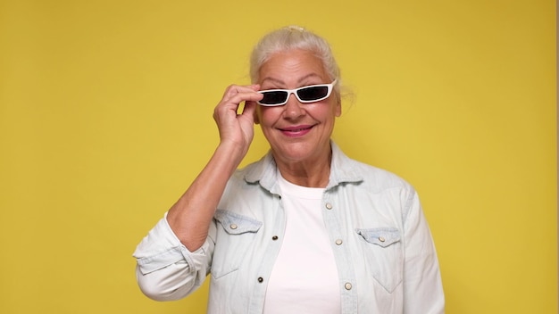 Une femme européenne âgée à lunettes regarde avec confiance la caméra en souriant