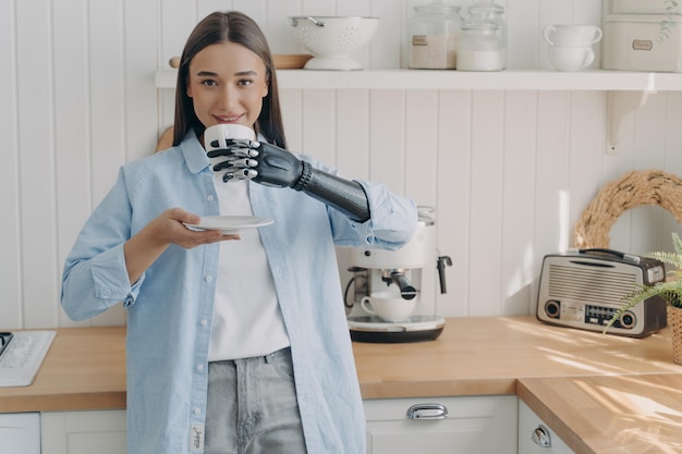 Une femme européenne handicapée heureuse tient une tasse de café avec une cyber-main Routine d'une personne amputée