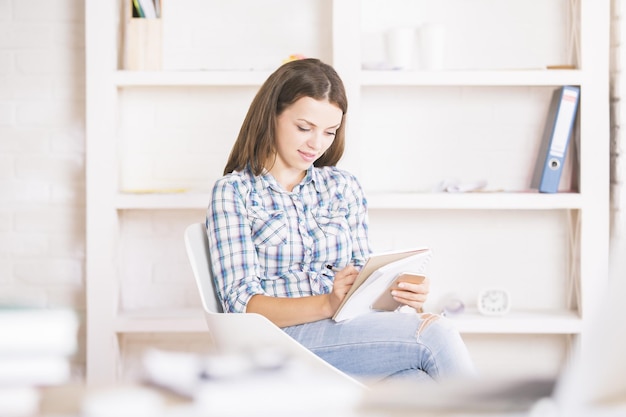 Femme européenne avec smartphone et bloc-notes