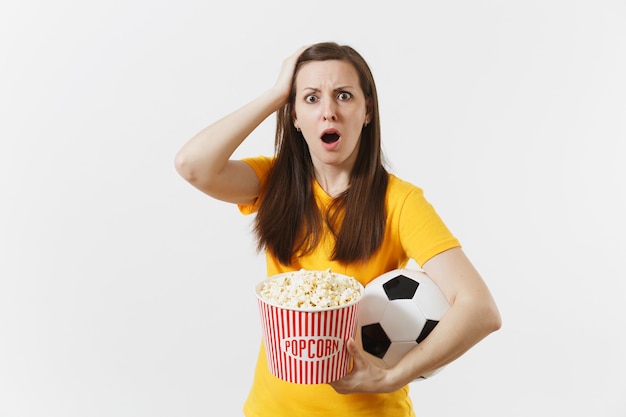 Femme européenne triste choquée, fan de football tenant un ballon de football, seau de pop-corn bouleversé par la perte ou le but de l'équipe préférée isolé sur fond blanc. Sport, jouer au football, encourager, concept de style de vie des fans